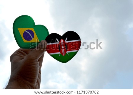 Hand holds a heart Shape Brazil and Kenya flag, love between two countries