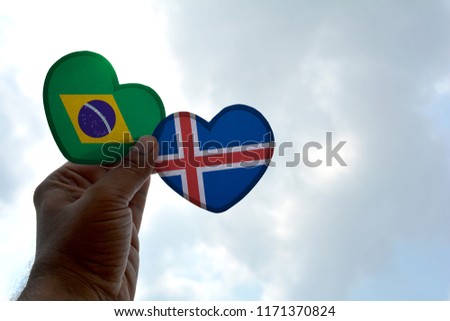 Hand holds a heart Shape Brazil and Iceland flag, love between two countries