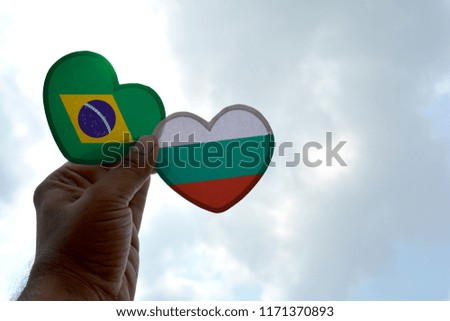 Hand holds a heart Shape Brazil and Bulgaria flag, love between two countries