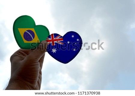 Hand holds a heart Shape Brazil and Australia flag, love between two countries