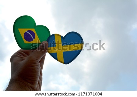 Hand holds a heart Shape Brazil and Sweden flag, love between two countries