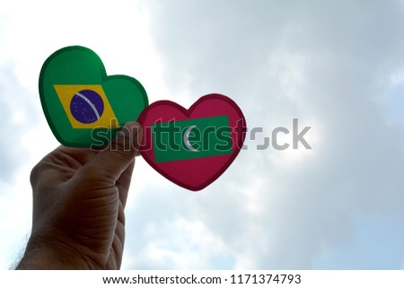 Hand holds a heart Shape Brazil and Maldive flag, love between two countries