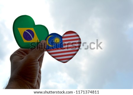 Hand holds a heart Shape Brazil and Malaysia flag, love between two countries