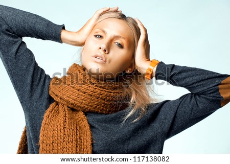 Fashion blonde woman wearing orange  scarf. Studio photo shooting