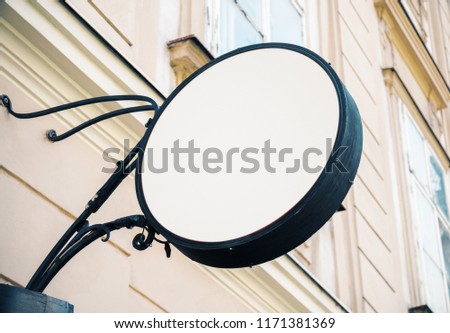 Empty round white signage on building with classical architecture and daylight. Mock up 
