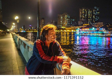Senior women traveler stand beside Pearl River in Guangzhou city China