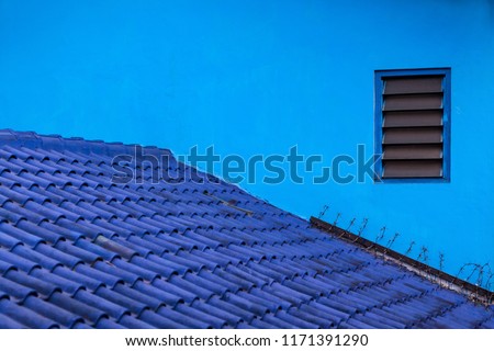 Blue background. House wall, tiled roof painted in various shades of blue color. Village Kampung Biru is popular place to visit for city walking tour. Travel destination in Malang East Java, Indonesia