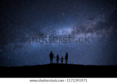 The family standing on the picturesque starry sky background