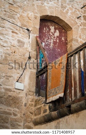 An old, covered wooden door against the backdrop of a stone peeling wall. Moroccan style. Africa, Morocco, Essaouira