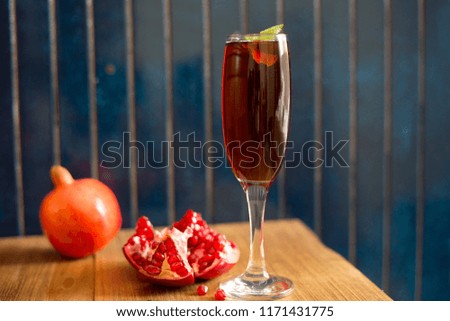 Fresh Pomegranate juice and whole Pomegranate  in a glass with rustic blue background