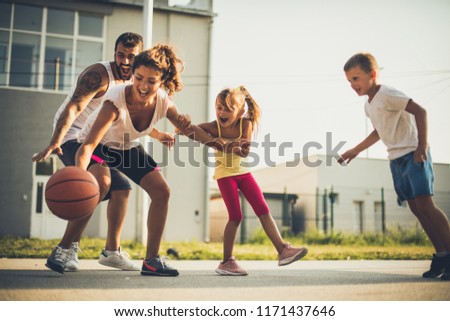 Happy family playing basketball together . Spring season. 