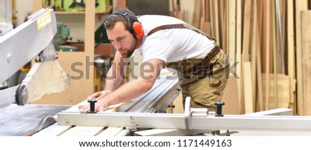 carpenter works in a joinery - workshop for woodworking and sawing Royalty-Free Stock Photo #1171449163