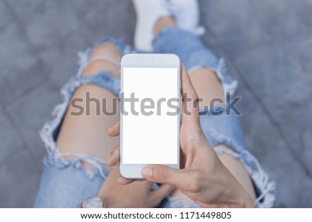 Mockup image of woman's hand holding and using white mobile phone at outdoor with copy space,blank screen for text.concept for business,people communication,technology electronic device. modern life s