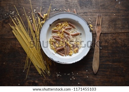 
Old dishes with pasta, wooden fork
