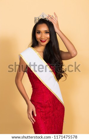 Miss Beauty Pageant Queen Contest in Asian Evening Ball Gown sequin dress with Diamond Crown Sash, fashion make up face eyes love heart hair style, studio lighting beige background isolated copy space Royalty-Free Stock Photo #1171475578