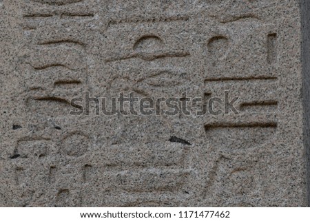 Ancient, worn hieroglyphics carved in sandstone closeup abstract texture background.  