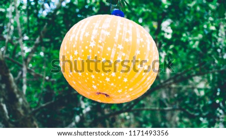 A garden yellow lamp for outdoor decoration with green garden and tree as background