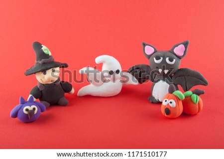 Group of plasticine halloween figures on red background. Owl, gnome, ghost, bat and pumpkin