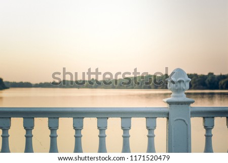 white classic fence frame in evening sunset time on river shore waterfront district for walking with soft colors and empty copy space for your text