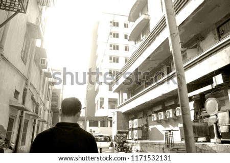 Man walking lonely near building.