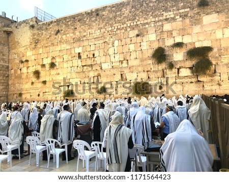 Orthodox Jewish men in Tallit prayer shawls standing for Shacharit sunrise prayer at the Western/Wailing Wall or Kotel, the holiest place in Judaism; Jerusalem Israel Royalty-Free Stock Photo #1171564423