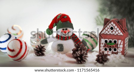toy snowman and a gingerbread house on a light background.