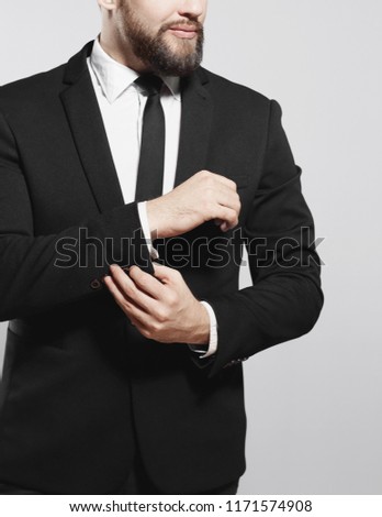serious businessman adjusting his cuff link on the sleeve of the shirt