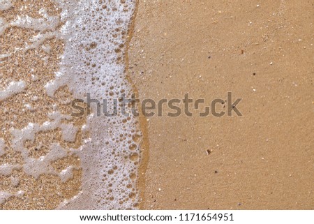 Soft wave of the sea on the sandy beach as background