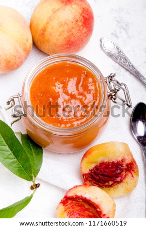 Homemade peach jam with organic fruit. Sweet preserves on a light background