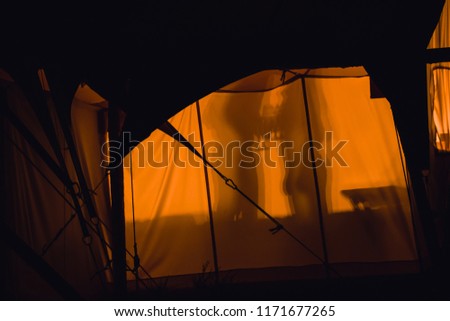 A Silhouetted Couple Sharing A Romantic Evening While Luxury Camping