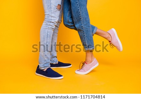 Affection feelings daydream meeting weekend holiday concept. Cropped portrait of legs in jeans sneakers, lovely romantic couple kissing hugging isolated on yellow background Royalty-Free Stock Photo #1171704814
