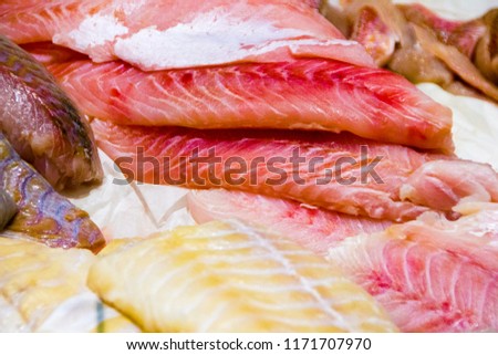 Freshly cut fish fillets on cold ice on display on a market, to keep it fresh