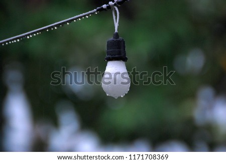 Closeup Round lamp with droplet hanging on the power line - blurred background