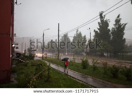 rain in the city, wet clothes, people go under umbrellas, fleeing from bad weather and water pouring from the sky, autumn weather, wet asphalt and city streets during a downpour
