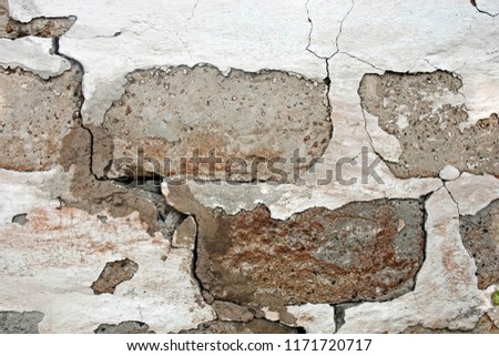 Old damaged brick walll with peeling white plaster. Front view. Texture. Royalty-Free Stock Photo #1171720717