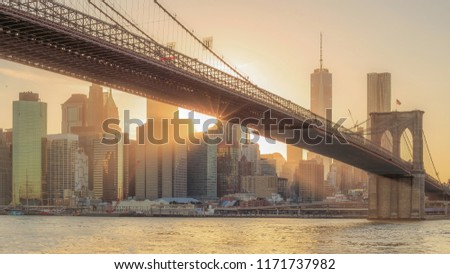 The panorama view of Brooklyn Bridge with Lower Manhattan at sunset in USA