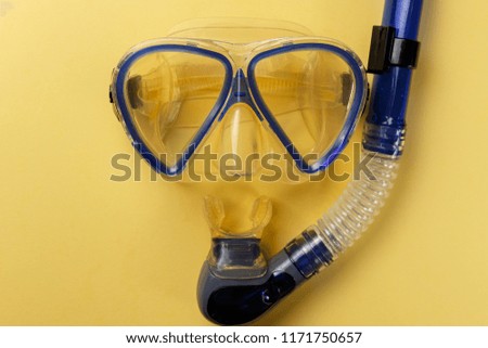 Diving equipment. Snorkeling mask and tube on yellow background. Colorful background. Top view. Copy space. Close up