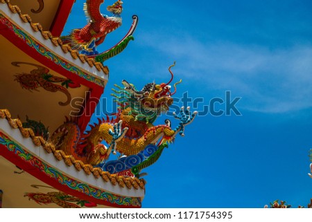 A very graceful dragon statue of a shrine. According to Chinese beliefs, in the bright summer sun in the background of a clear sky.