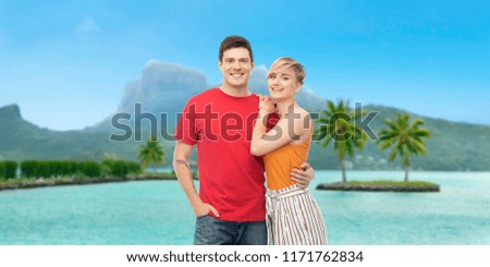 travel, tourism and summer holidays concept - happy smiling couple hugging at touristic resort over bora bora island beach background