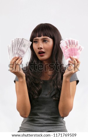 dollars money and rupiah surprised asian women with high rate on money changer.