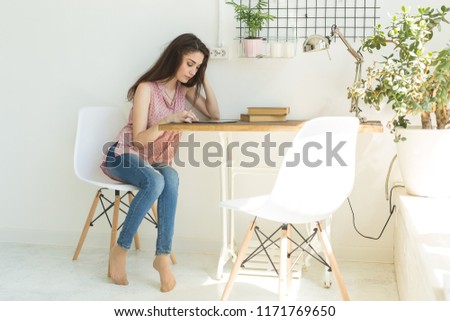 Technology and people concept - Young beautiful woman sitting at the white table with tablet