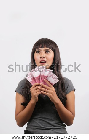 rupiah money holding indonesian women looking blank space isolated on white background.