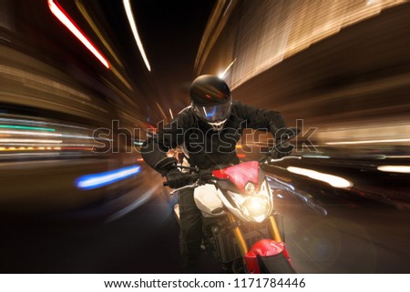Motorcycle drives at night through the lights of the city