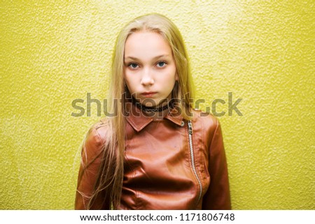 photo of teenage girl on a yellow wall background