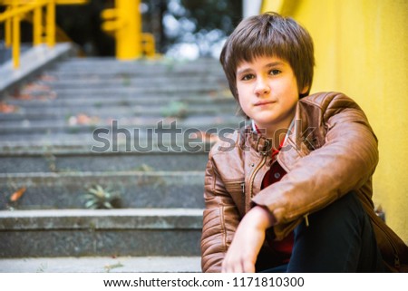 photo of boy teenager sitting on the steps in the park