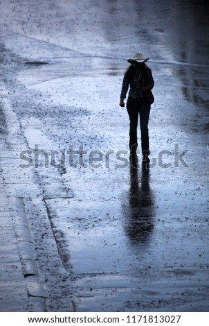 Cowgirl walking in the rain