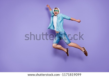 Full body size length photo of trendy handsome guy on vacation wearing casual blue jeans, color sun glasses and sunhat, rushing far away in air to rescue, fooling, over pastel violet purple background
