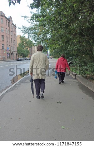 man and woman walking on the sidewalk after rain
					