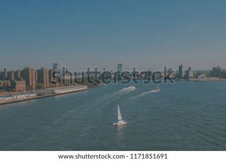 City on the riverside. White sailboat on the Hudson river. New York postcard wallpaper concept. 