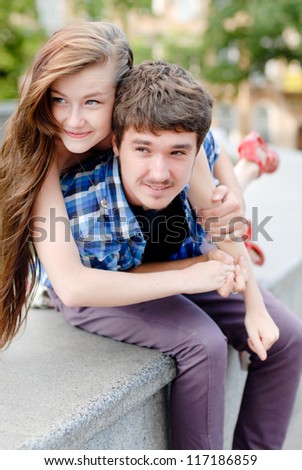 Young happy smiling couple beautiful woman & handsome man in love embracing outdoors in city